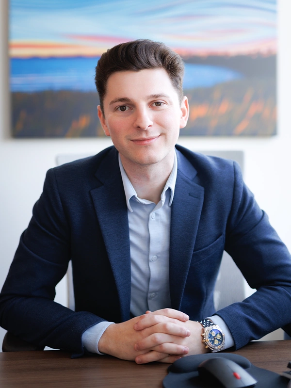 Aaron Gelmon seated at a desk in a professional office setting, representing his role as a dental lease consultant and educator.